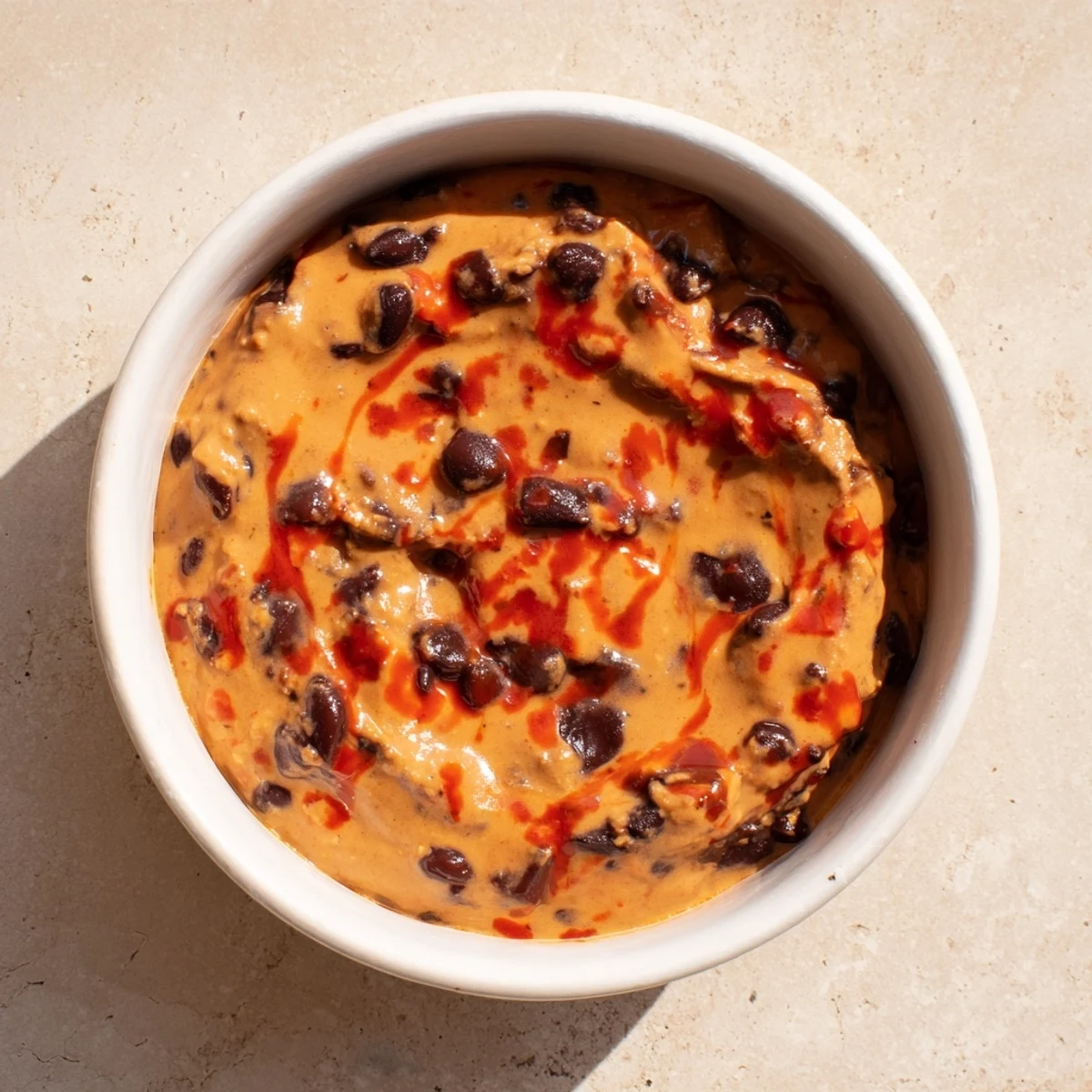 Creamy Spicy Black Bean Dip, smooth and vibrant, ready to be scooped with tortilla chips.