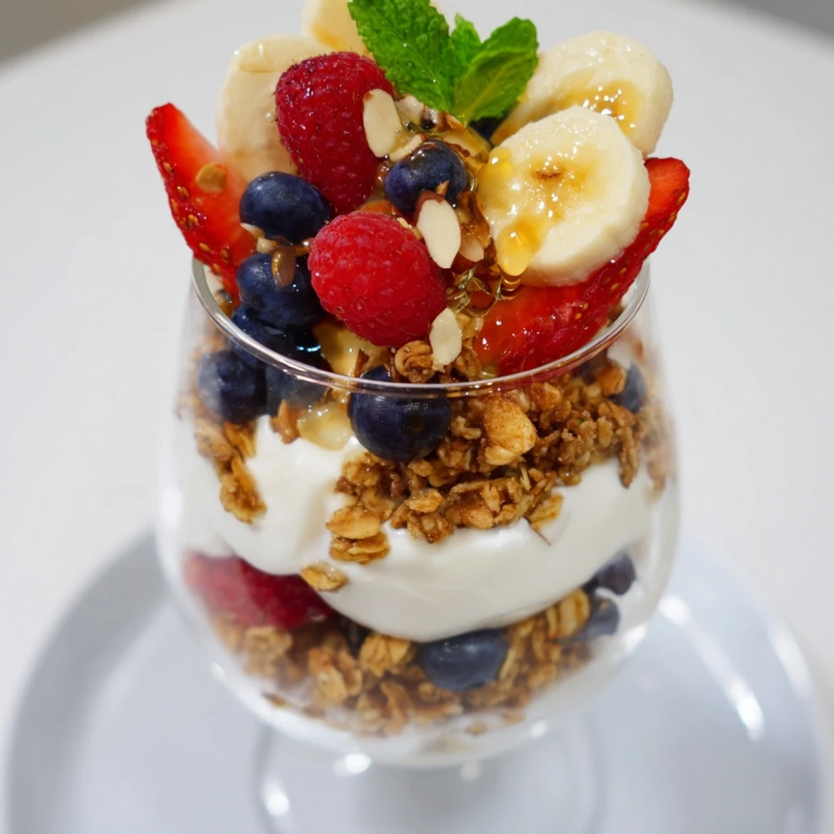 Refreshing yogurt and granola parfait glasses layered with colorful fresh berries for brunch.