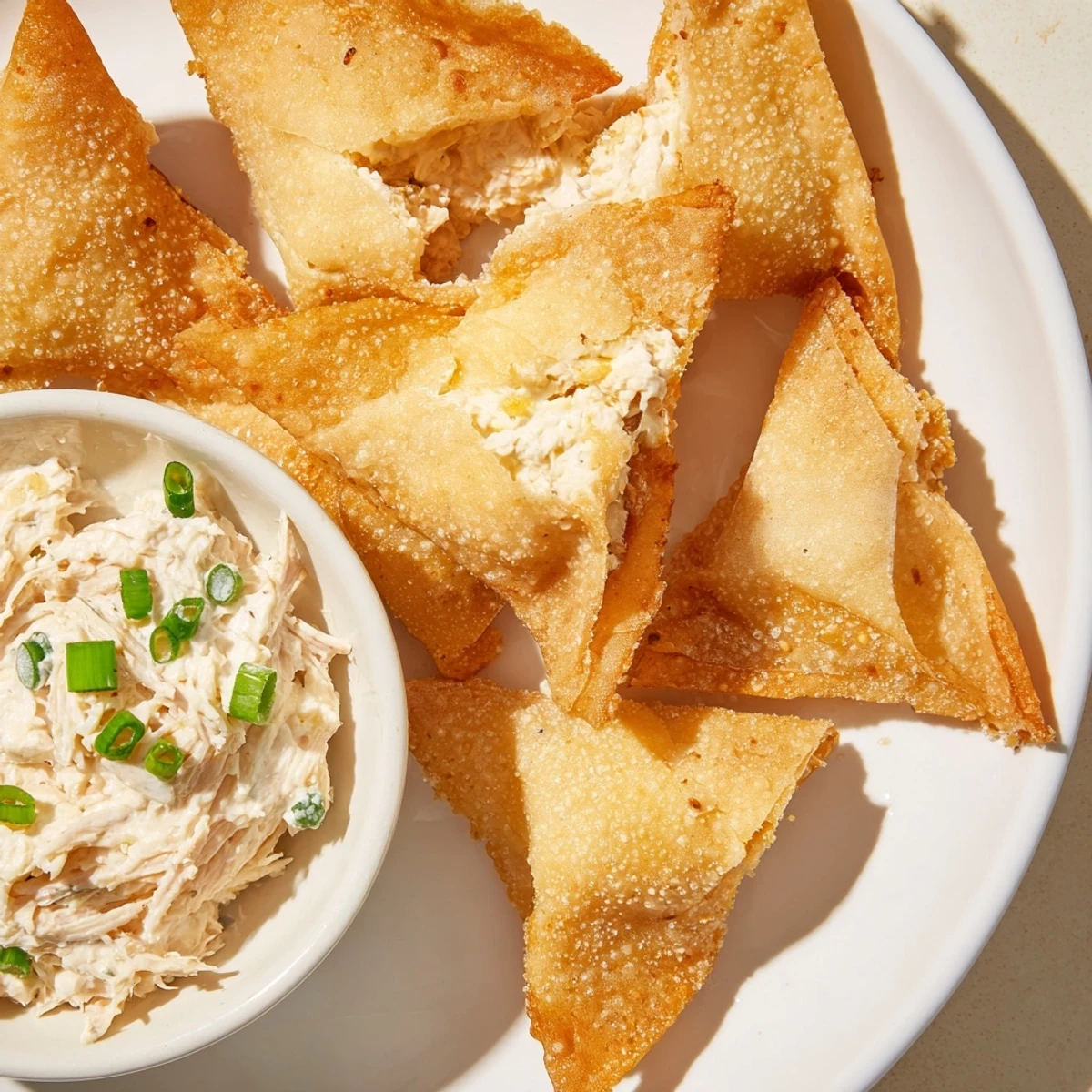 Golden crisp air fryer lumpia chips alongside a creamy chicken cream cheese dip, ready to enjoy.