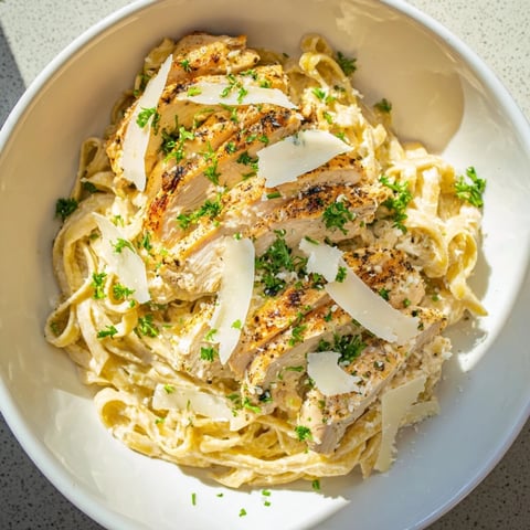 Plate of Spicy Cajun Chicken Alfredo, creamy sauce coating fettuccine, topped with sliced chicken.