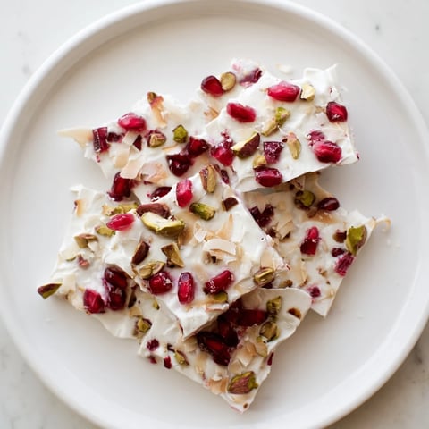 A colorful slice of Frozen Yogurt Bark with vibrant pomegranate and crunchy pistachios.