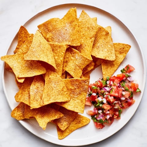 Golden and crispy air-fryer tortilla chips with a vibrant, fresh homemade salsa for dipping.