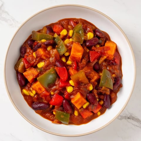 A steaming bowl of veggie chili, a colorful vegan and vegetarian main dish.