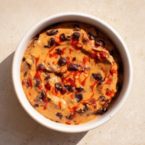 Creamy Spicy Black Bean Dip, smooth and vibrant, ready to be scooped with tortilla chips.