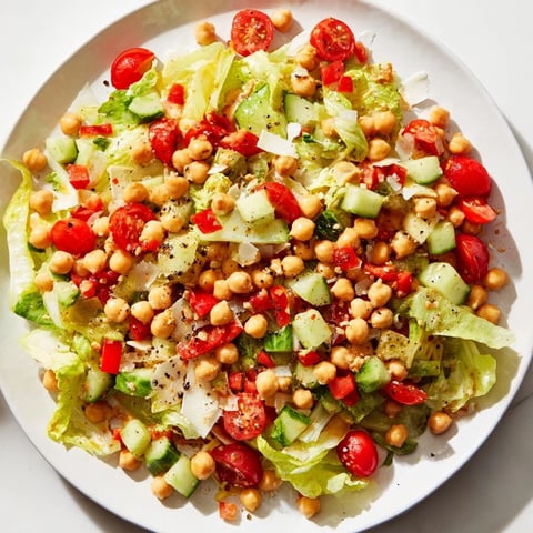 A colorful bowl of La Scala chopped chickpea salad, full of fresh vegetables and tangy dressing.
