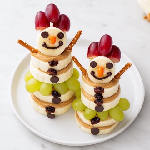 Smiling banana peanut butter snowmen, a delightful and healthy snack, displayed on a plate ready to serve.