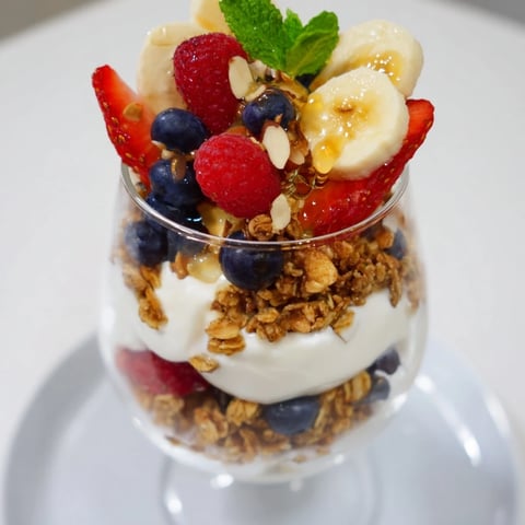Refreshing yogurt and granola parfait glasses layered with colorful fresh berries for brunch.