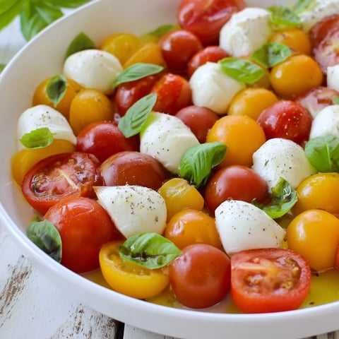 Fresh and vibrant appetizer wreath with cherry tomatoes, basil, and creamy mozzarella, perfect for sharing.