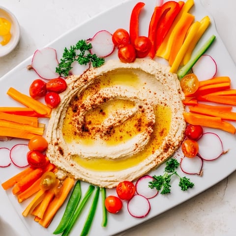 The River Delta Flow appetizer: a colorful arrangement of fresh veggies framing creamy hummus river.