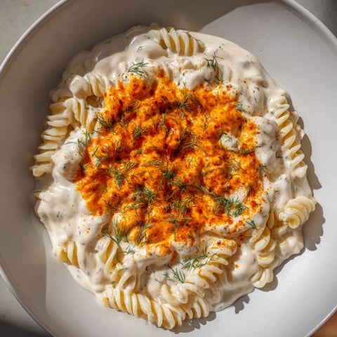 Steaming bowl of Turkish Yogurt Pasta, with creamy white yogurt sauce and spiced butter drizzled over it.
