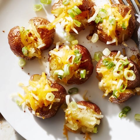 Crispy smashed green onion potato bombs topped with melted cheese and fresh herbs.  