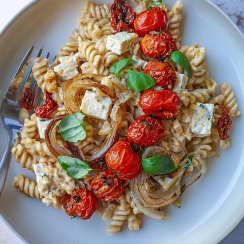 Savory Baked Feta Pasta served with fresh basil, bursting with Mediterranean flavors and tidbits.  