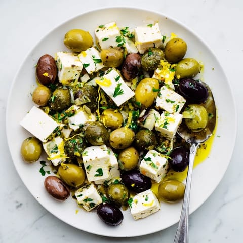 This Holiday Mix: Mixed Olives with Feta Cubes recipe shows olives glistening with an herby marinade.