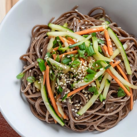 Close-up of perfectly layered Chilled Noodle Lunch Cups, featuring vibrant cucumber ribbons and sesame seeds.