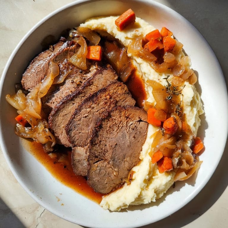 A close-up shot of a plate with Classic Brisket & Mashed Sweet Potatoes, ready for a comforting bite.