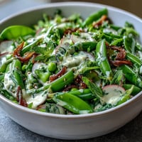 Bright Snap Pea and Radish Spring Salad with Tahini, topped with sesame seeds.